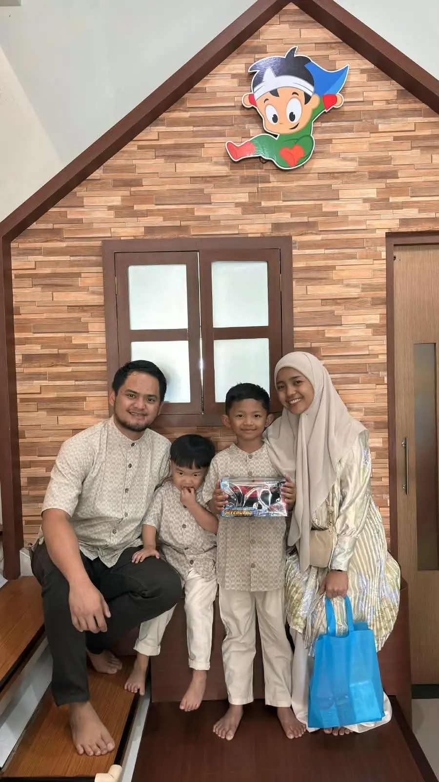 Pasien anak bahagia memegang hadiah mainan mobil remot bersama keluarga